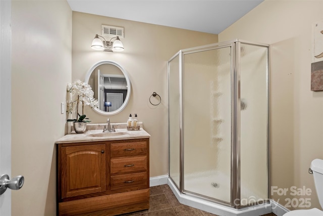 bathroom with tile patterned flooring, toilet, vanity, visible vents, and a stall shower