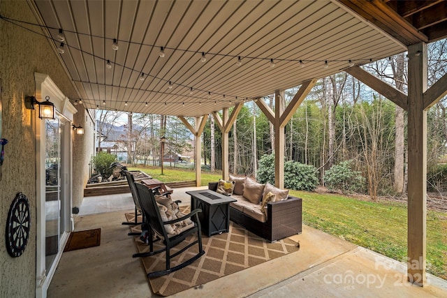 view of patio with an outdoor living space with a fire pit