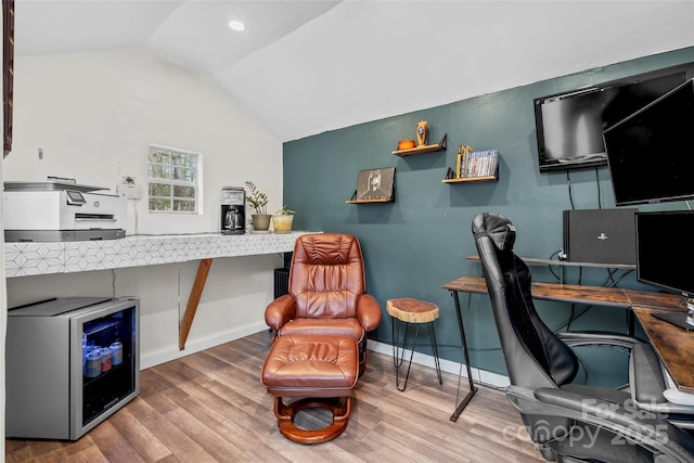 office with beverage cooler, baseboards, vaulted ceiling, and wood finished floors