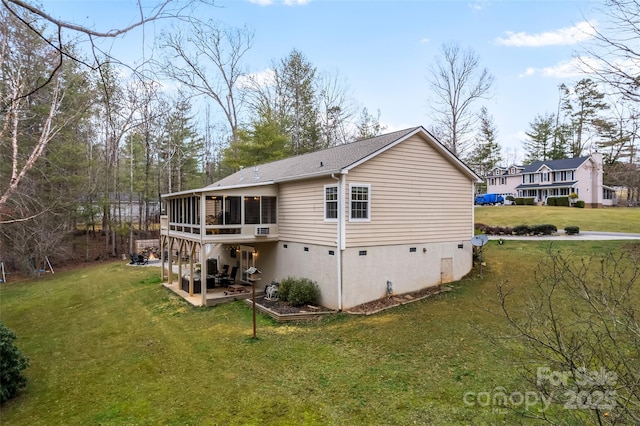 rear view of property featuring crawl space, a lawn, a patio area, and a sunroom