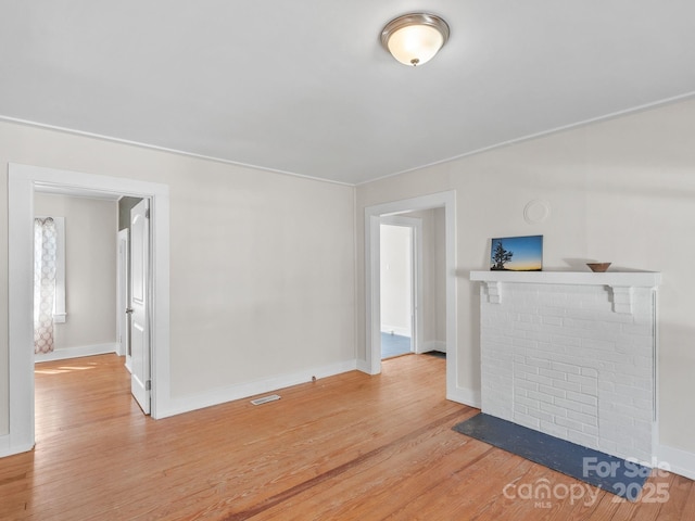 interior space featuring visible vents, light wood-type flooring, and baseboards