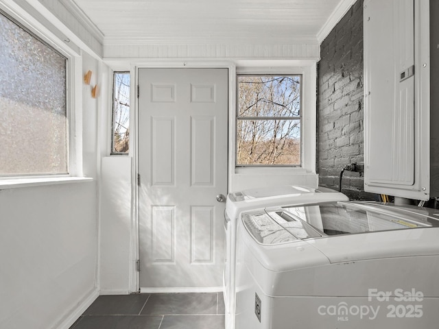 foyer entrance with electric panel, independent washer and dryer, dark tile patterned flooring, and ornamental molding