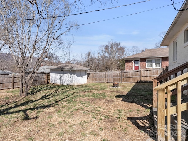 view of yard with an outdoor structure, a storage unit, and a fenced backyard