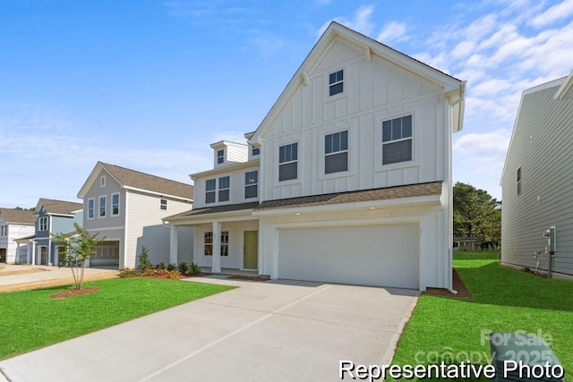 view of front facade with an attached garage, concrete driveway, board and batten siding, and a front yard