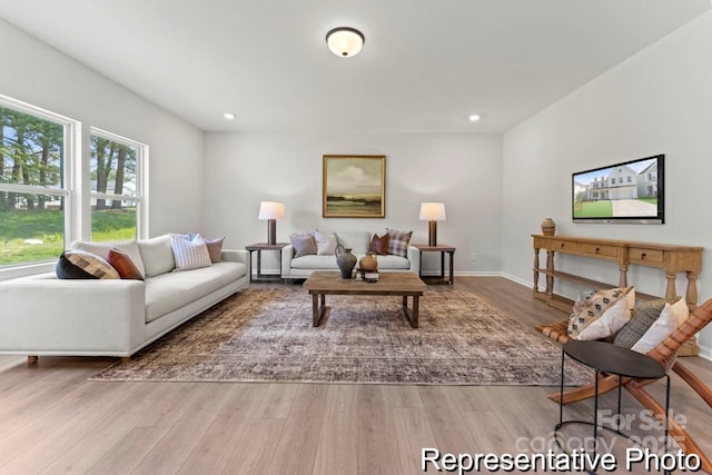 living room featuring baseboards, wood finished floors, and recessed lighting