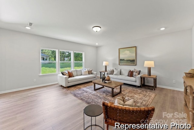 living area with recessed lighting, baseboards, and light wood finished floors