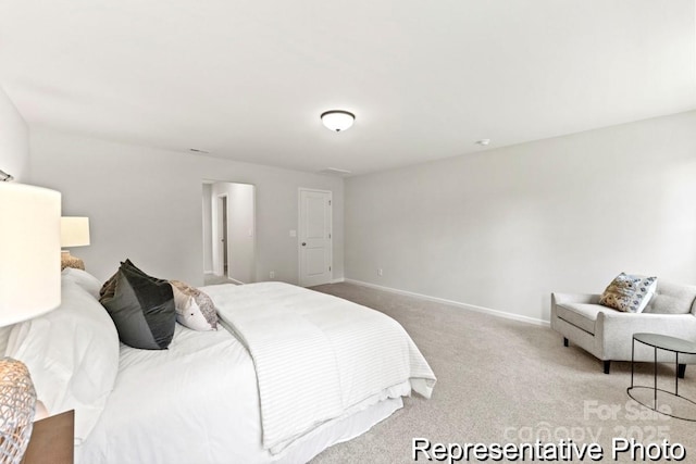 bedroom with baseboards and light colored carpet