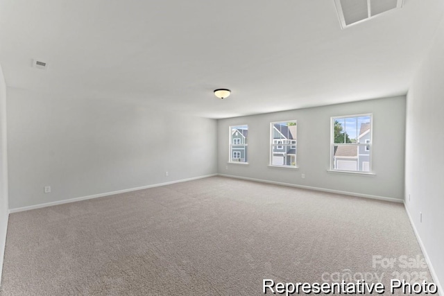 empty room with baseboards, visible vents, and light colored carpet