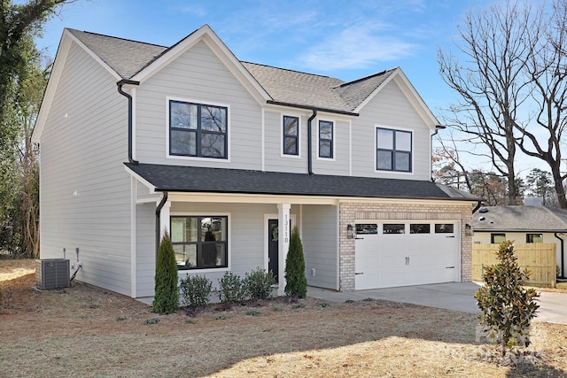 view of front of home with a garage, concrete driveway, fence, central AC, and brick siding