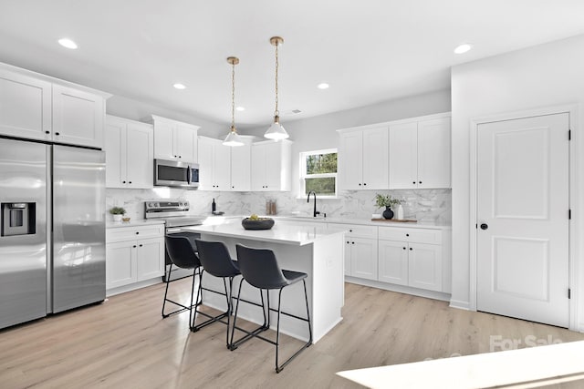 kitchen with stainless steel appliances, white cabinets, and a kitchen breakfast bar