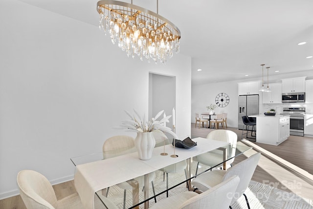 dining room with a chandelier, light wood-type flooring, baseboards, and recessed lighting