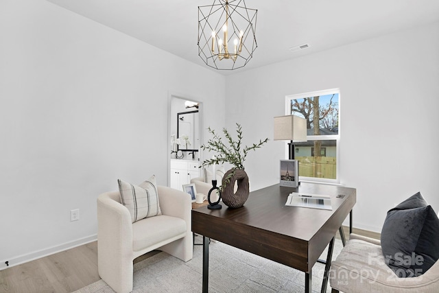 office space with light wood-style flooring, visible vents, a chandelier, and baseboards