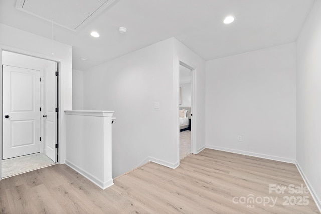 interior space with attic access, light wood-type flooring, baseboards, and recessed lighting