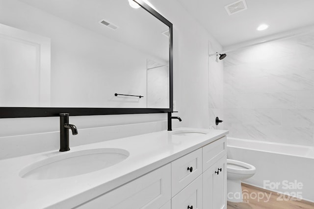 bathroom with toilet, visible vents, and a sink