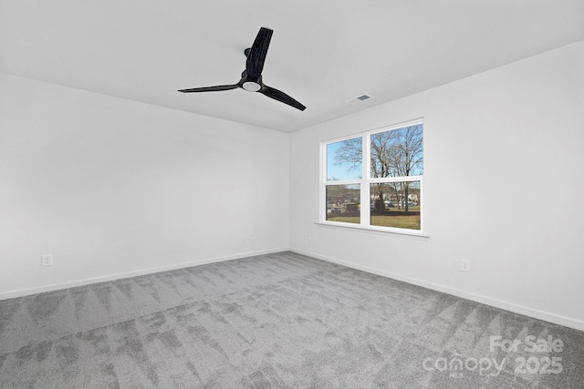 carpeted empty room with baseboards, visible vents, and a ceiling fan