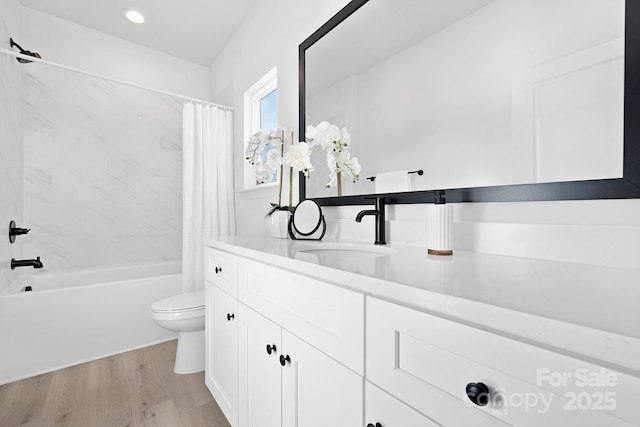 full bath with recessed lighting, toilet, shower / bath combo with shower curtain, vanity, and wood finished floors