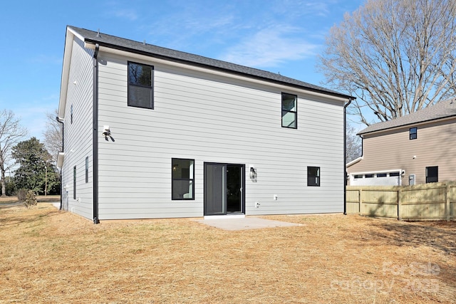 rear view of property with a lawn, a patio area, and fence