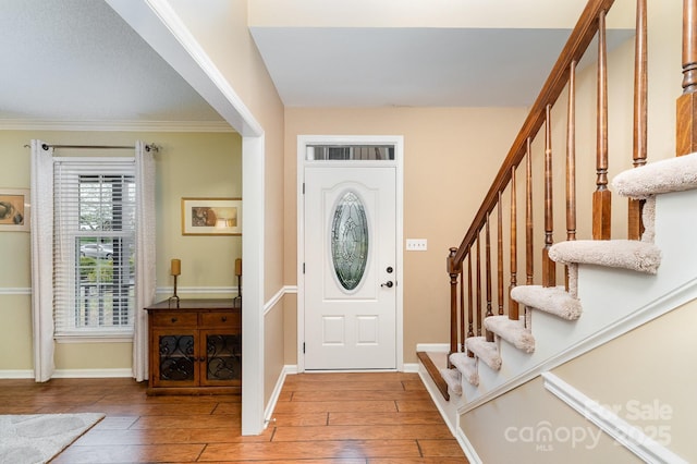 entryway with stairway, baseboards, and light wood-style floors