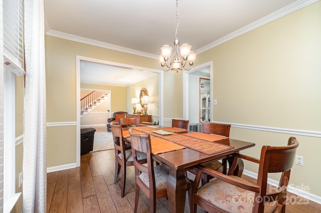 dining space featuring baseboards, an inviting chandelier, ornamental molding, stairs, and hardwood / wood-style flooring