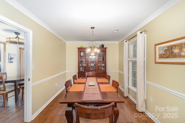 dining room featuring ornamental molding, baseboards, and hardwood / wood-style floors