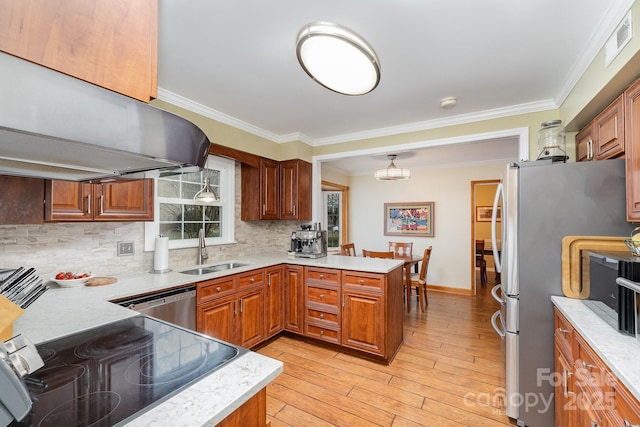 kitchen featuring a sink, under cabinet range hood, stainless steel appliances, a peninsula, and crown molding