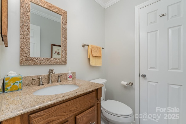 bathroom with vanity, crown molding, and toilet