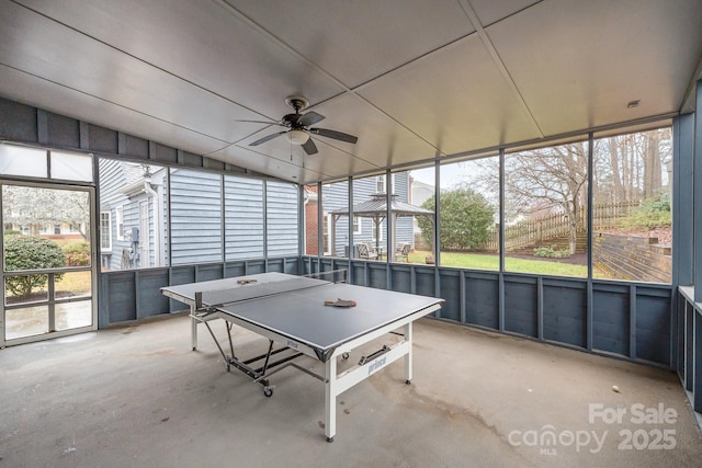 game room with concrete flooring, a healthy amount of sunlight, a ceiling fan, and vaulted ceiling