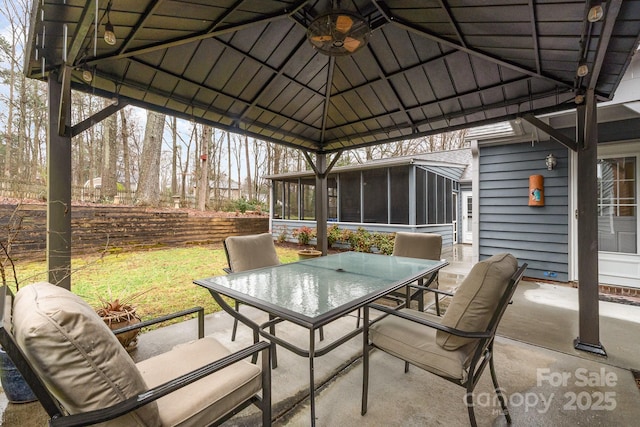 view of patio / terrace with a gazebo, outdoor dining space, ceiling fan, and a sunroom