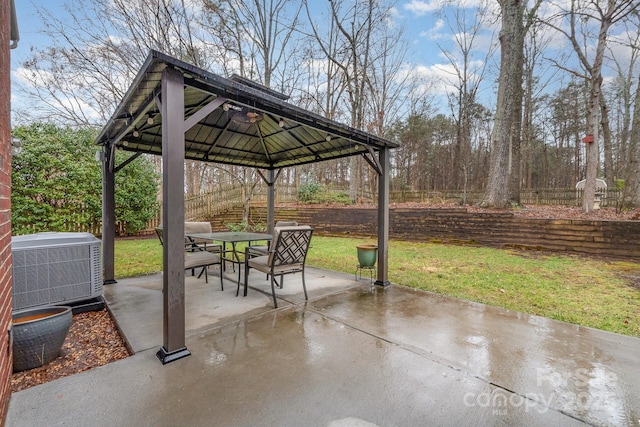 view of patio with a gazebo, outdoor dining area, central AC unit, and fence