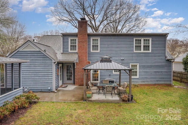 rear view of property featuring a lawn, a patio, fence, a gazebo, and a chimney