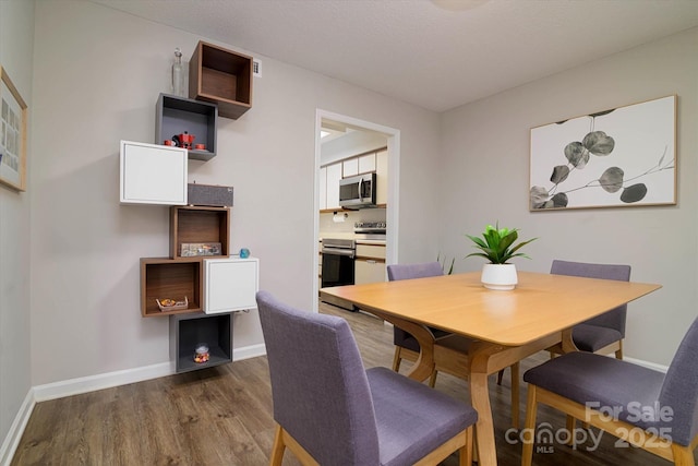 dining area featuring baseboards and wood finished floors