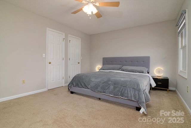 carpeted bedroom with ceiling fan and baseboards