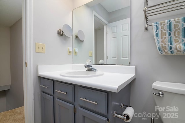 half bathroom featuring vanity and toilet