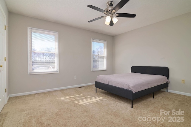 carpeted bedroom with baseboards and a ceiling fan