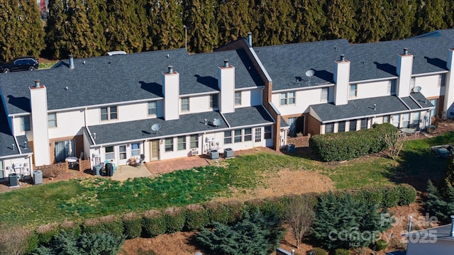 back of house featuring a patio, central AC unit, a yard, a residential view, and a chimney