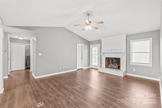 unfurnished living room with baseboards, a ceiling fan, lofted ceiling, wood finished floors, and a fireplace