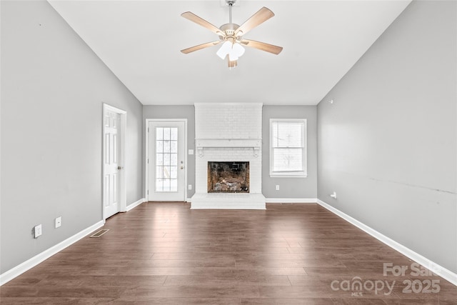 unfurnished living room featuring dark wood-style floors, vaulted ceiling, and plenty of natural light