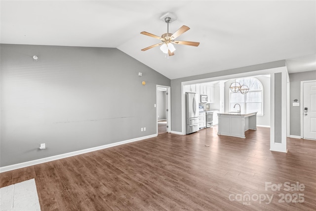 unfurnished living room with lofted ceiling, a sink, a ceiling fan, baseboards, and dark wood finished floors