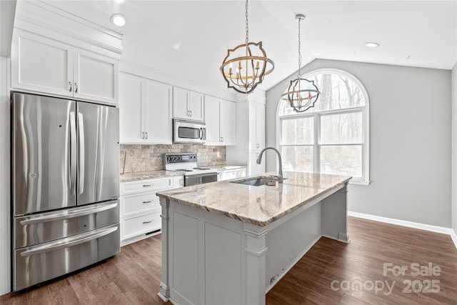 kitchen featuring a kitchen island with sink, a sink, white cabinets, appliances with stainless steel finishes, and decorative backsplash