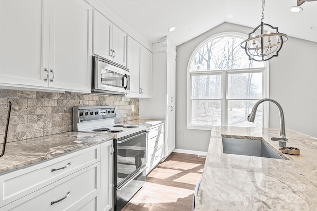 kitchen featuring a sink, white cabinets, electric range oven, tasteful backsplash, and stainless steel microwave