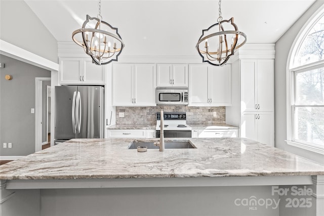 kitchen featuring white cabinetry, plenty of natural light, appliances with stainless steel finishes, and a notable chandelier