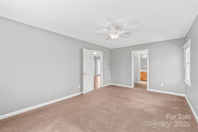 unfurnished bedroom with ensuite bath, baseboards, ceiling fan, and carpet flooring