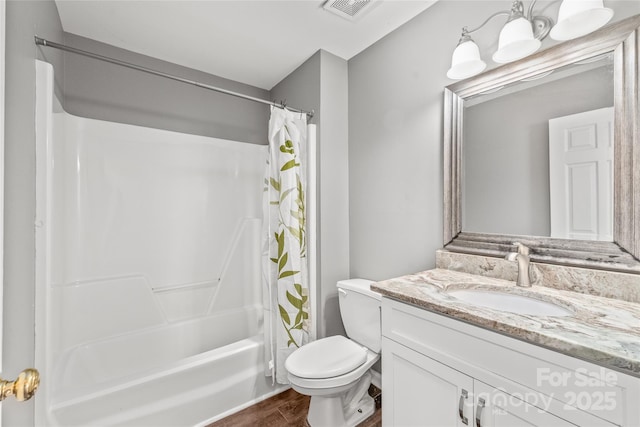 bathroom featuring visible vents, toilet, wood finished floors, shower / bath combination with curtain, and vanity