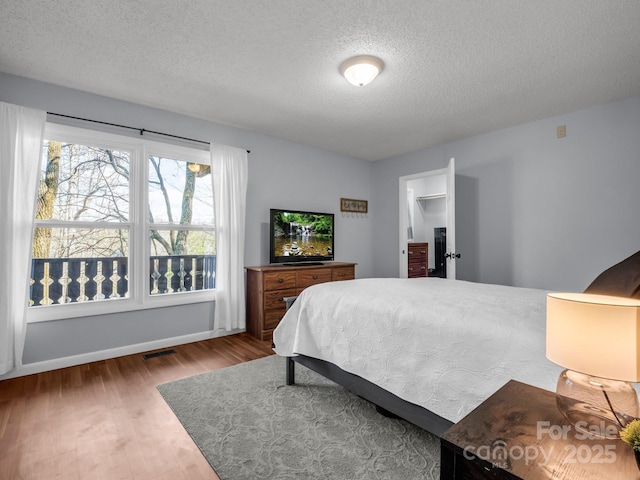 232 Stonebrook Dr, Hendersonville, NC 28791 - bedroom featuring a textured ceiling, wood finished floors, and baseboards
