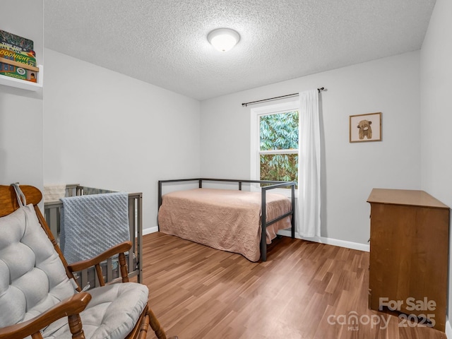 232 Stonebrook Dr, Hendersonville, NC 28791 - bedroom with wood finished floors, a textured ceiling, and baseboards
