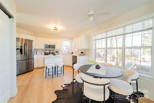 dining space featuring light wood-style floors and ceiling fan