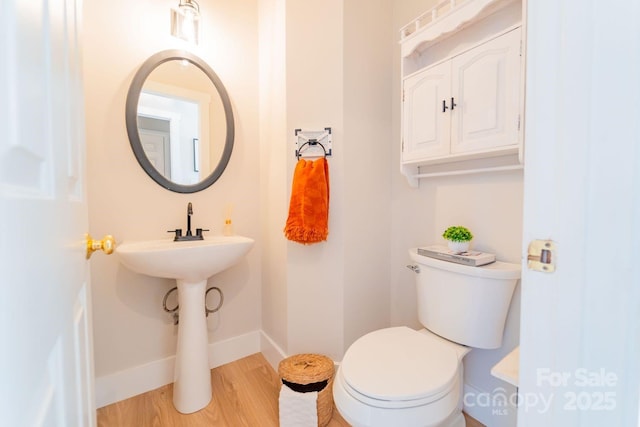 bathroom featuring wood finished floors, toilet, and baseboards