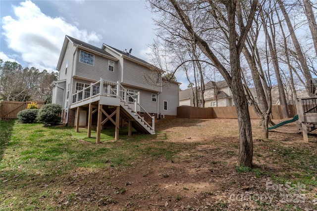 back of house with a fenced backyard, stairway, a deck, and a playground