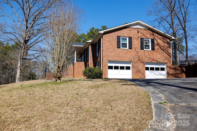 view of side of home featuring a garage, a yard, aphalt driveway, and brick siding