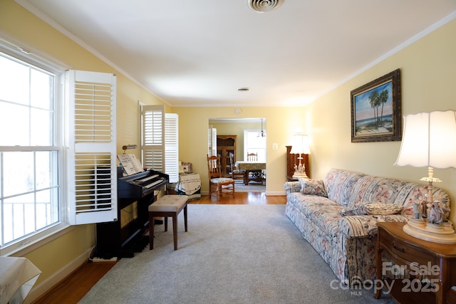 living room featuring a healthy amount of sunlight, crown molding, and wood finished floors